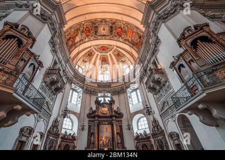 Ultrawide view of central dome ceiling with organ pipe pulpit inside Salzburg Cathedral Stock Photo