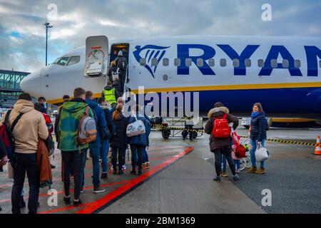 Riga Airport RIX, Latvia 01/30/20: Ryanair airplane with a long line of passengers patiently ready to embark.Logo of the irish low cost airliner,crowd Stock Photo