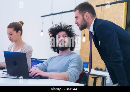 Working group discussing ideas for project sharing opinions while checking business plan on laptop, female web designer presenting to boss her job usi Stock Photo