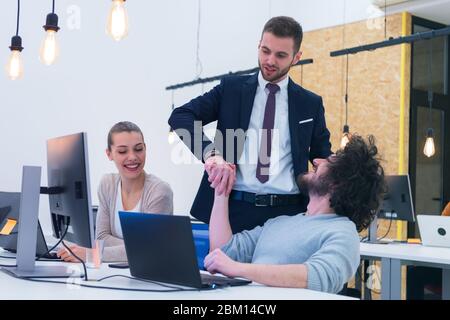 Working group discussing ideas for project sharing opinions while checking business plan on laptop, female web designer presenting to boss her job usi Stock Photo
