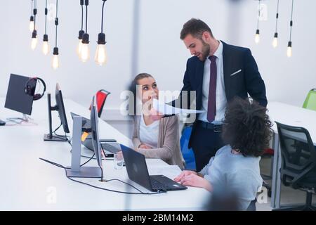 Working group discussing ideas for project sharing opinions while checking business plan on laptop, female web designer presenting to boss her job usi Stock Photo