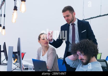 Working group discussing ideas for project sharing opinions while checking business plan on laptop, female web designer presenting to boss her job usi Stock Photo