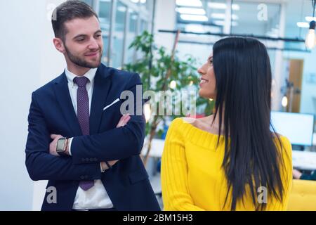 Portrait of two young co workers standing at workplace inside modern co working space. Stock Photo