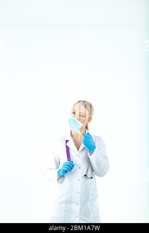 doctor nurse puts on a protective mask. A nurse in a respiratory mask. Put on masks. Wear gloves. beautiful blonde doctor shows how to put on a protec Stock Photo