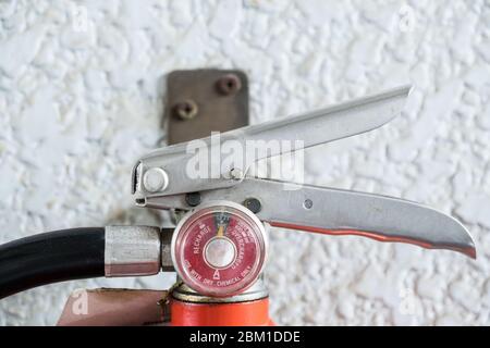 Close-up of the fire extinguisher pressure gauge for check to ready to use in the event of a fire which near the white concrete wall in the office bui Stock Photo