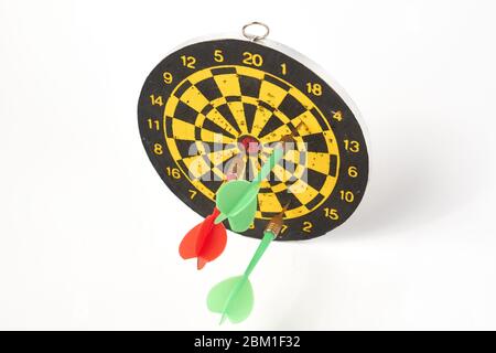 darts target darts all in holes with two green darts and one red on a white background isolate Stock Photo