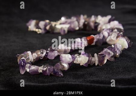 beads from crumbs amethyst semiprecious stone on black velor. close up Stock Photo