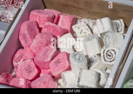 Lokum the “Turkish Delight”, famous Istanbul sweet dessert, confectionery shop. Pink and white color dislay on counter top during street food festival Stock Photo
