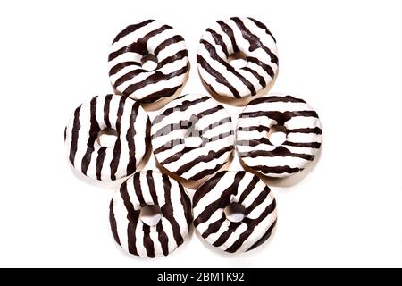 Glazed striped donuts on white background, isolated. Party food concept with copy space. Top view. Stock Photo