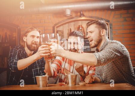 Funny old friends gathered in bar for beer, clink glasses. Stock Photo