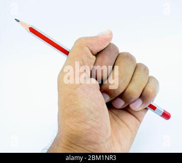 Person holding holding a dark red colored wood pencil crayon in his gentle hand Stock Photo