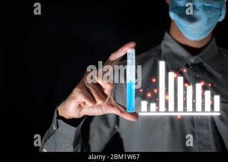 Business man ware mask and hold alcohol for clean bacteria or virus with bad business graph durin covid-19 disease around the world Stock Photo