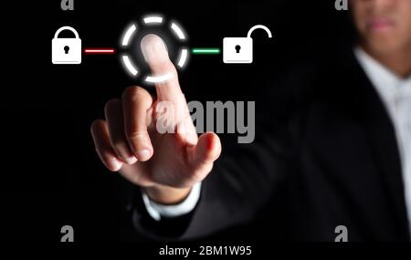 businessman touch on graphic for icon with fingerprint to unlock the key in office to scan for access and authorization connect online social business Stock Photo
