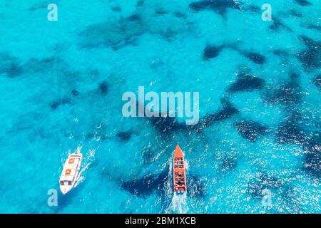 Pleasure Speedboat sailing on blue clear water of large coral reef with guided tour. Concept travel ship. Aerial view. Stock Photo