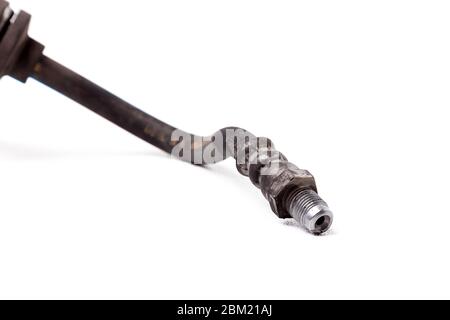 Used brake hose from a car close-up on a white isolated background in a photo studio - a high-pressure hose and a metal tip for connecting to a cylind Stock Photo