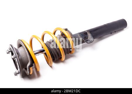 Metal shock absorber for car suspension in black with a yellow spring on a white isolated background in a photo studio in a horizontal position. Spare Stock Photo