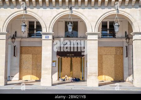 A homeless sleeping in front of the Angelina Tea Shop, on the Rue de Rivoli, in Paris during the lock down Coronavirus covid-19 Stock Photo