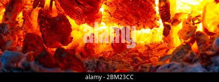 red hot coals in a blast furnace for metal melting. metal mining and processing industry. Red coals from a burnt fire made of wood. panoramic Stock Photo