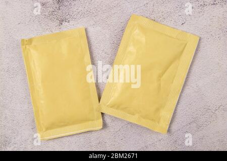 Two white paper sachets isolated on marble background. Top views with clear space Stock Photo