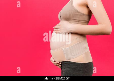 Close up of pregnant woman wearing pregnancy corset against backpain at  gray background with copy space. Orthopedic abdominal support belt concept  Stock Photo - Alamy