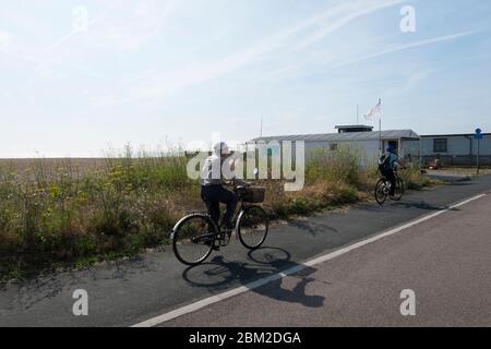 A middle aged couple cycling along the cycle path which runs along the front from Deal to Walmer and Kingsdown, Kent, UK Stock Photo