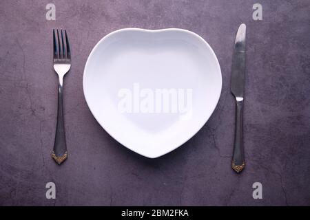 Clean empty white plate with knife and fork, Stock Photo