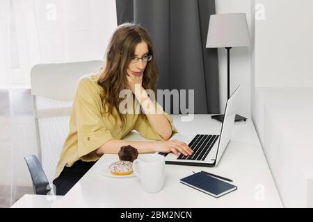 Due to quarantine caused by the covid-19 virus, the woman remained at home. A woman works at a computer without going outside. Stock Photo