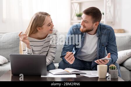 Positive young couple calculating finances at home Stock Photo