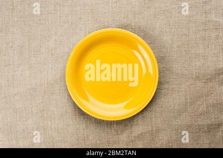 Yellow plate on canvas, top view. Stock Photo