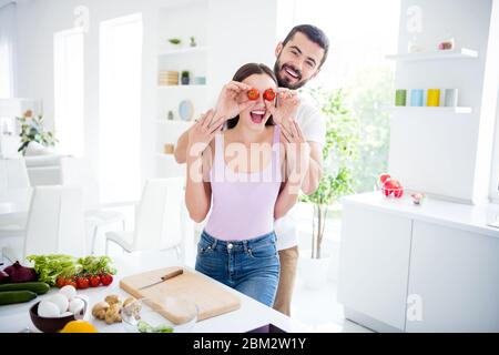 Portrait of crazy two people prepare organic dish meal man close cover eyes face woman scream enjoy cook humor gourmet healthy nutrition in kitchen Stock Photo