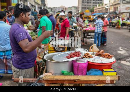 A street vendor selling iftar items in road side at Kawran Bazar in Dhaka, Bangladesh on May 06, 2020. Stock Photo