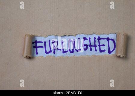 Furloughed Text written in torn paper. Medical concept Stock Photo