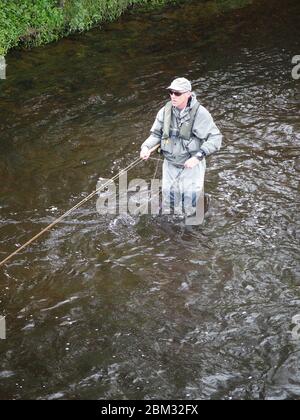 Fisherman standing in river Stock Photo - Alamy