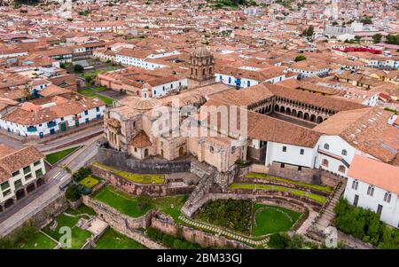 Aerial side view over empty Qorikancha gardens, Inca temple of the Sun in Cusco, and the empty streets of the city because of Coronavirus Stock Photo