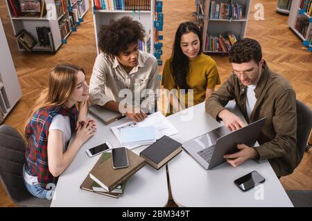University students are studying in a library together. Concept of teamwork and preparation Stock Photo