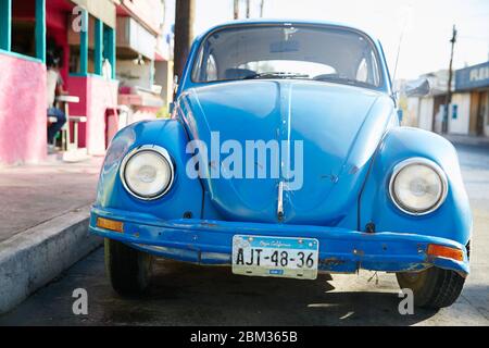 An old Volkswagen Beetle is parked on a colorful street in Cabo San Lukas, Mexico Stock Photo