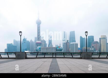 The skyline of Shanghai in the mist seen from The Bund waterfront promenade along the Huangpu River, China. Stock Photo