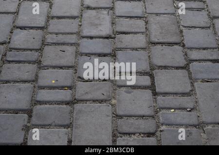Brick pavement. Gray cobblestone pavement, background photo with perspective effect Stock Photo
