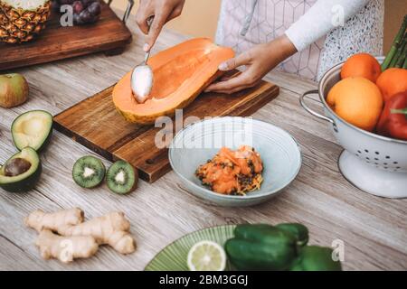 Woman chef preparing fruit and vegetable summer salad - Healthy lifestyle nutrition concept - Focus on left hand holding spoon Stock Photo