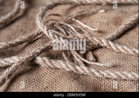 twine and burlap on a black wooden background, still life, texture Stock Photo