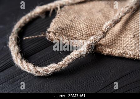 twine and burlap on a black wooden background, still life, texture Stock Photo