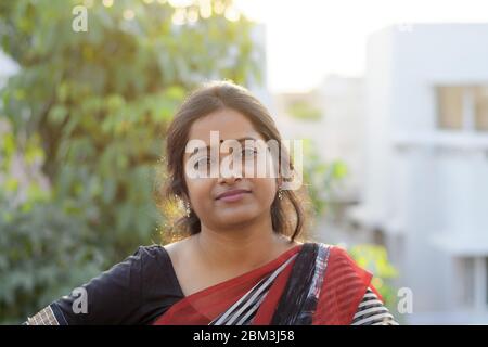 Portrait of an Indian brunette woman on rooftop at sunset time Stock Photo