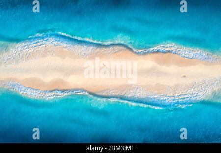 Aerial view of blue sea with waves on the both sides and people Stock Photo