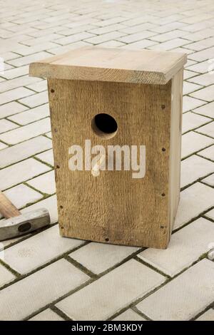 Ready birdhouse on the stone floor. Help the birds in spring Stock Photo