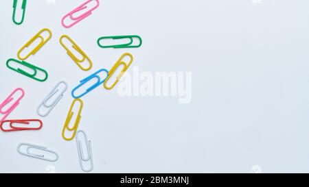 Multi-colored paper clips on a white background. Top view. Close up. Copy space. Stock Photo