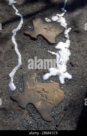 Bastrop County, Texas USA, September 9 2011: Melted aluminum from a garage flows down a pathway of Texas-shaped flagstones on the site of a house that was destroyed by the massive wildfires that swept through this wooded Circle D neighborhood. ©Bob Daemmrich Stock Photo