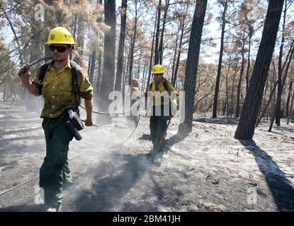 Bastrop, Texas USA, September 13, 2011: Firefighters wearing protective gear and carrying firefighting equipment continue to monitor and put out small fires a week after massive wildfires swept through the area. ©Marjorie Kamys Cotera/Daemmrich Photography Stock Photo