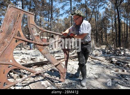 Bastrop Texas USA, September 2011: Family sorts through damaged home after massive wildfires swept through wooded neighborhoods, burning more than 1400 homes in the area in early September. ©Marjorie Kamys Cotera/Daemmrich Photography Stock Photo