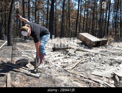 Bastrop Texas USA, September 2011: Resident sorts through damaged home after massive wildfires swept through wooded neighborhoods, burning more than 1400 homes in the area in early September. ©Marjorie Kamys Cotera/Daemmrich Photography Stock Photo