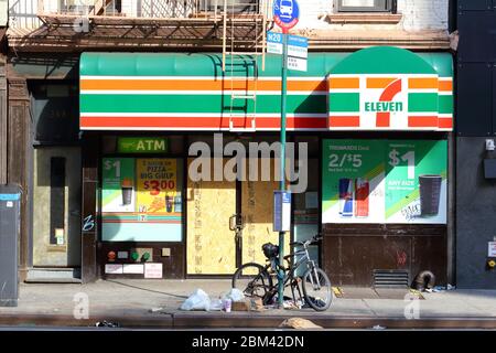 A closed 7-Eleven with boarded up windows and doors in New York Stock Photo